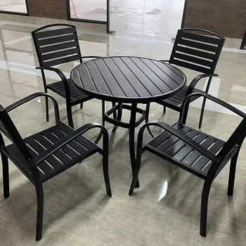 Vienkāršu plastmasas-koka āra galdi un krēsli, uzstādīts āra mazs kafijas galdiņš, atpūtas kaltas dzelzs galdi un krēsli